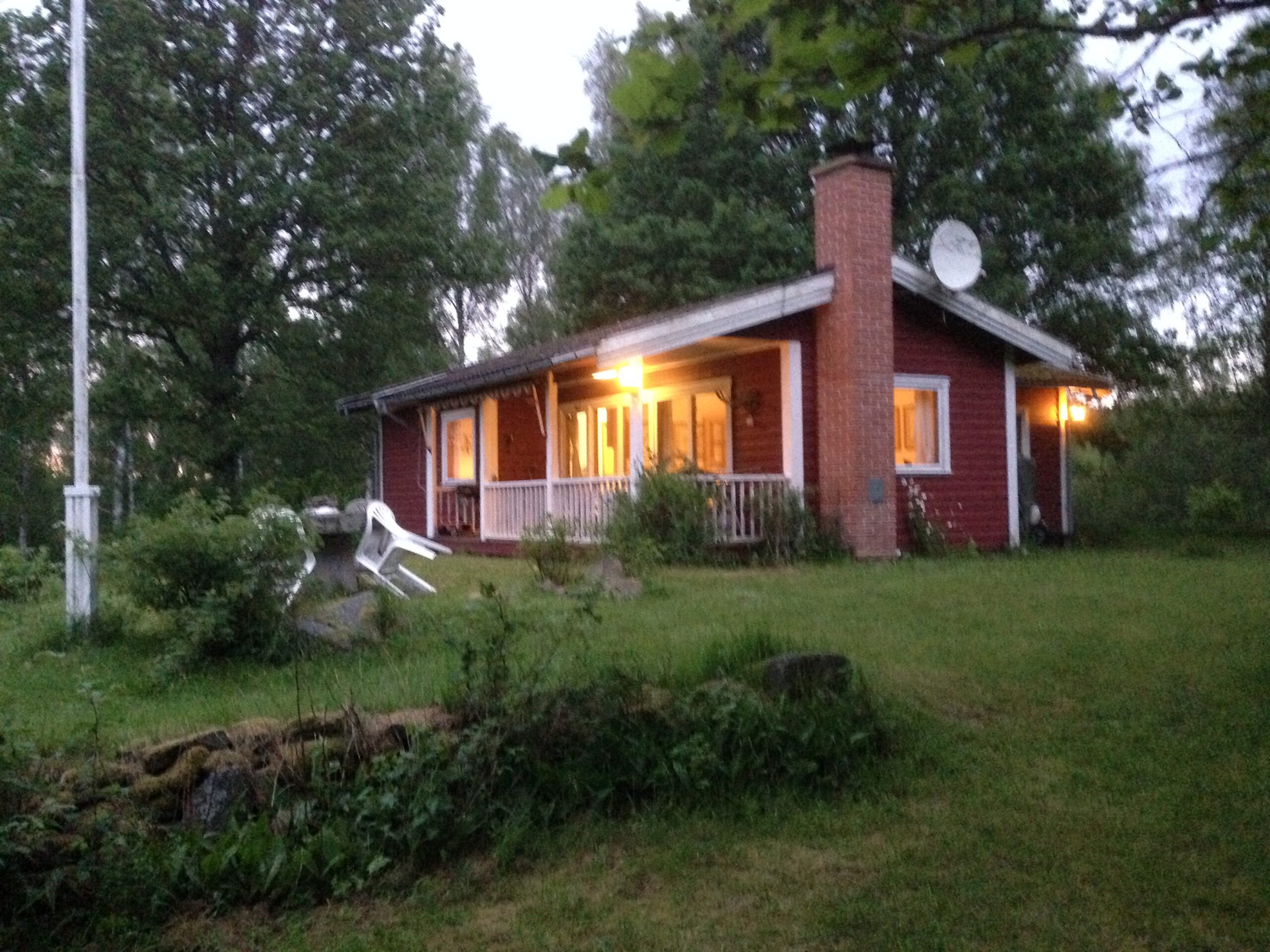 Rotes Ferienhaus Grannelia mit Terrasse am Abend